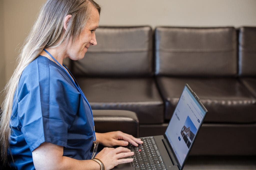 A massage therapy student preparing for the day on a laptop